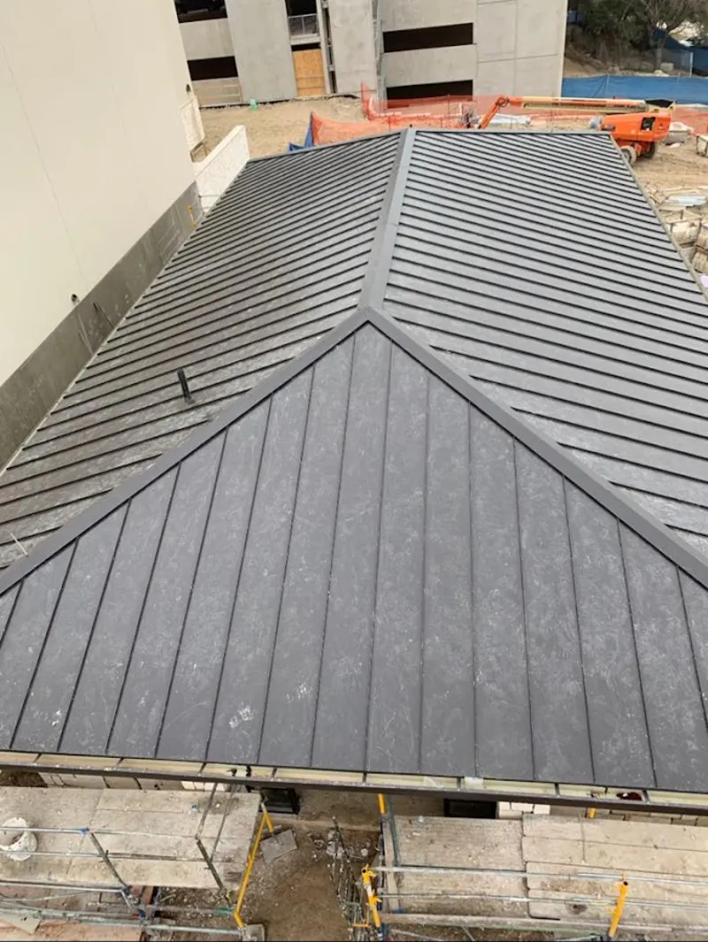 Commercial metal roof construction with crane equipment in Ferguson